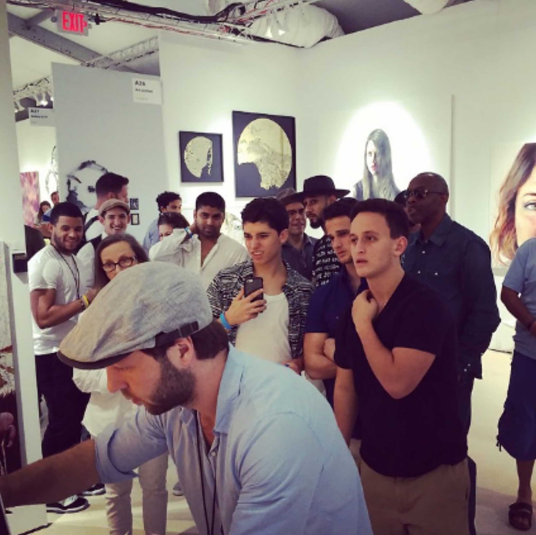 Max Zorn working on a tape artwork live at Scope Miami Beach 2013, surrounded by an interested crowd including Swizz Beatz.