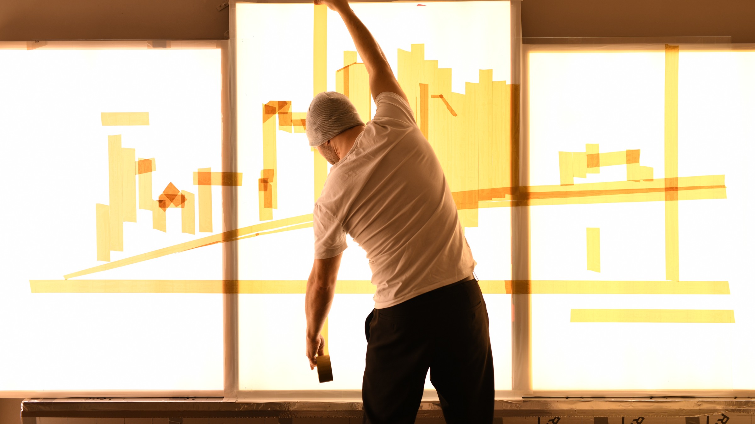 Max Zorn reaches across Dream to apply a long strip of tape during the early construction of its skyline.