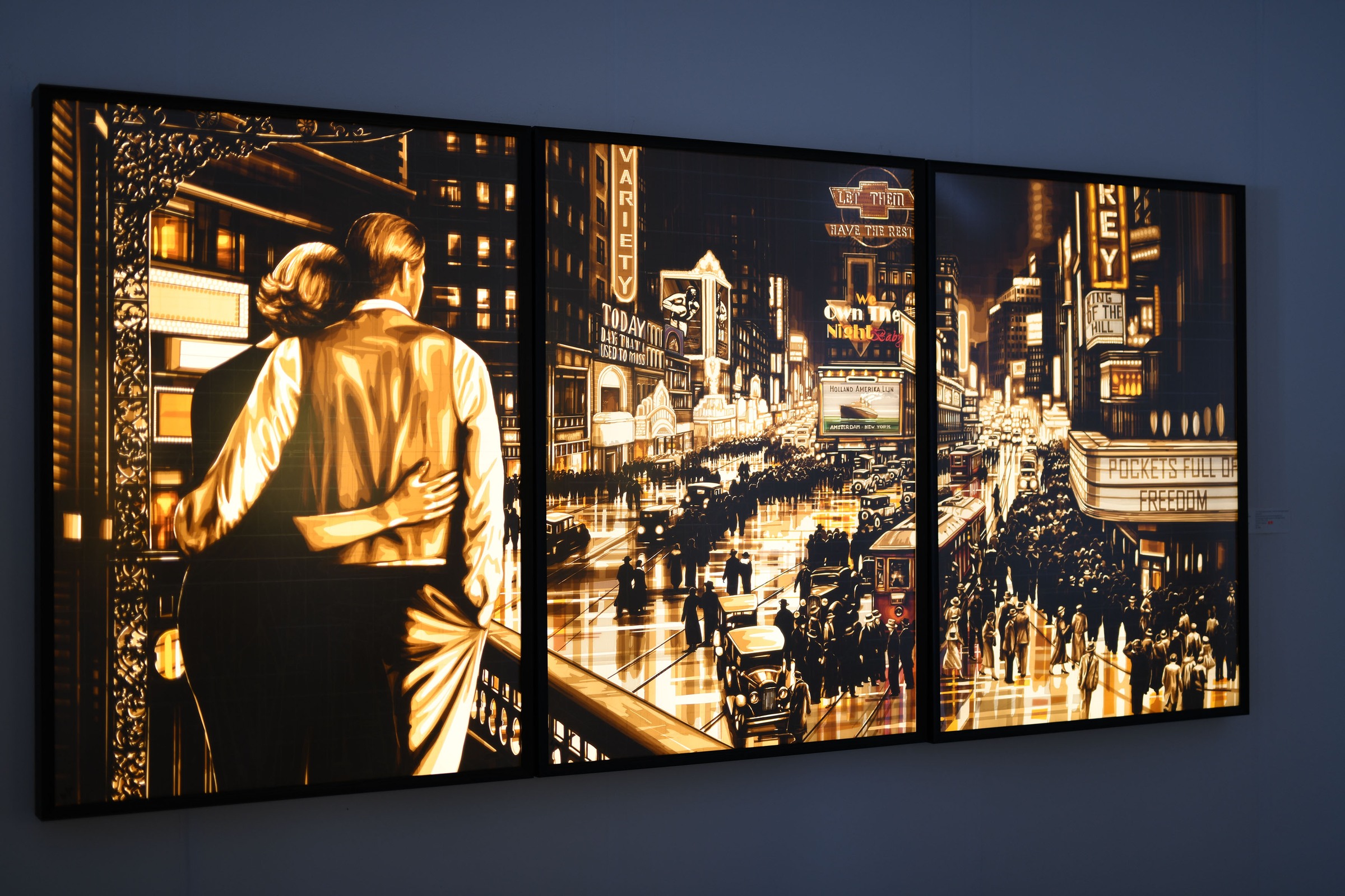 Let them have the rest… by Max Zorn, an illuminated tape-art triptych in black frames with a couple above a crowded theatre district.