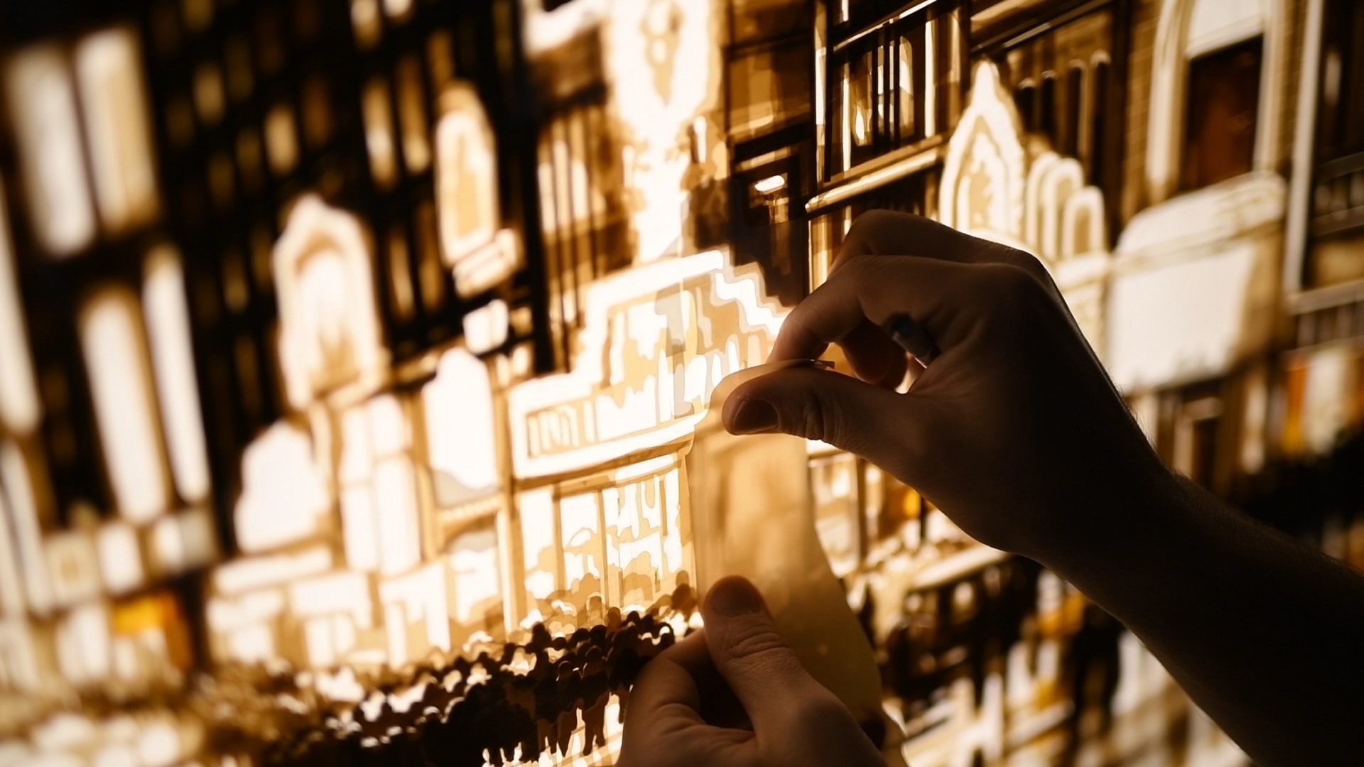 Max Zorn holds a cut strip of packing tape against the illuminated buildings of Let them have the rest…