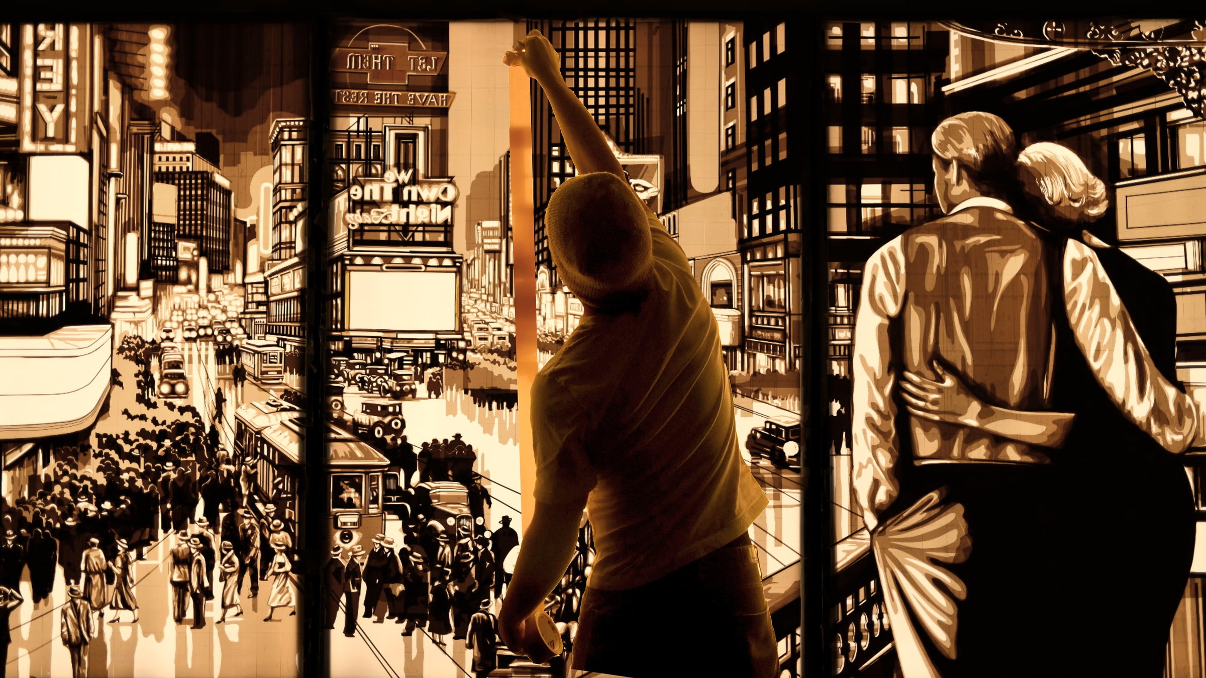 Max Zorn reaches up across Let them have the rest…, a large illuminated tape-art cityscape with an embracing couple.