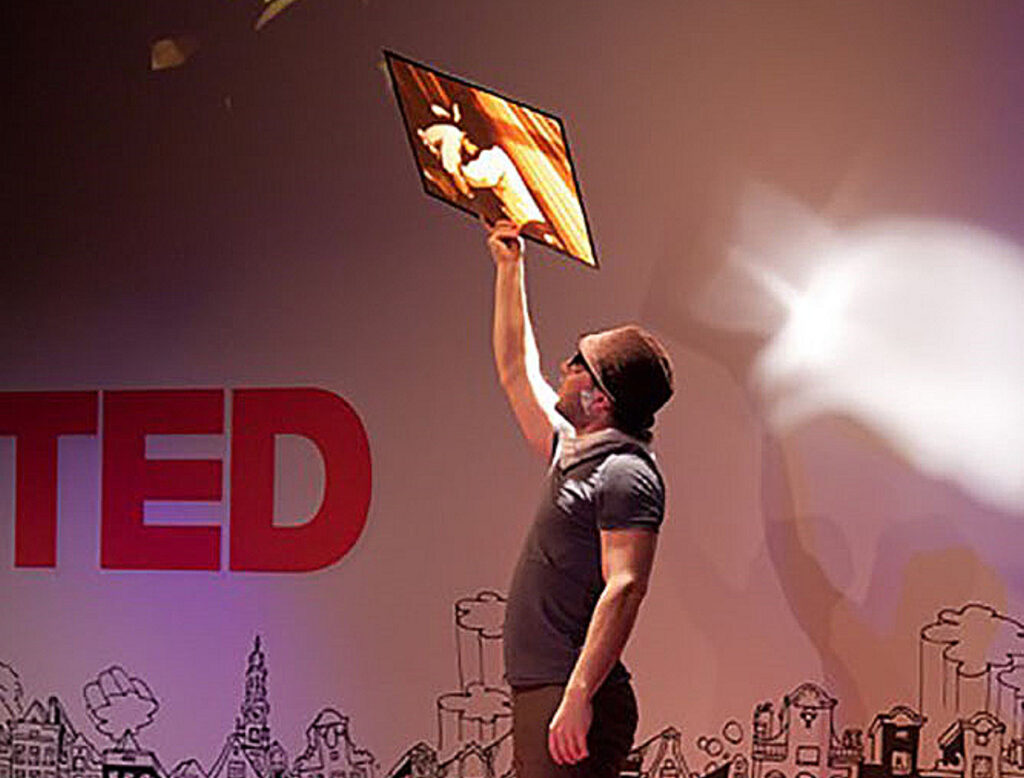 Max Zorn holding tape artwork during TED Talk in Amsterdam.